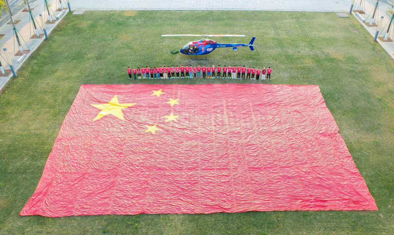 WHA Parachute Demonstration Team with a large-format national display flag and helicopter